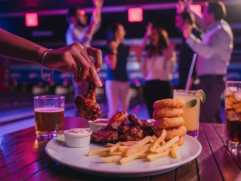 Alitas, papas y bebidas mientras compañeros de trabajo celebran en las pistas de Playzone